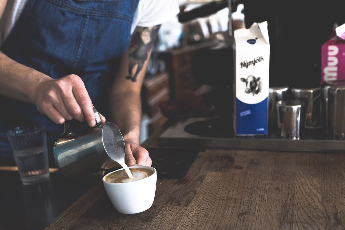 Barista nalieva mlieko do kávy
